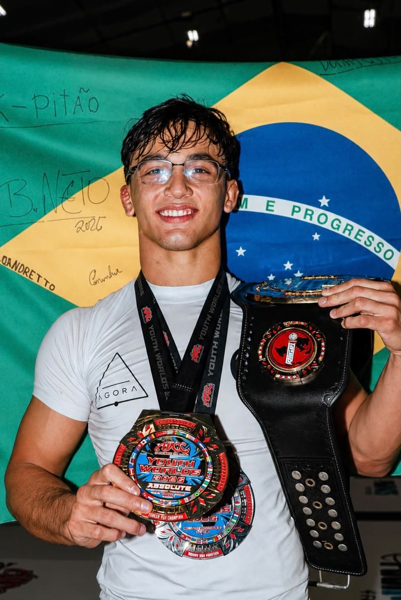 Vitória com Propósito — Isaque com cinturão e medalhas diante da bandeira brasileira